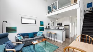 Un appartamento moderno con soggiorno, cucina e zona pranzo.
