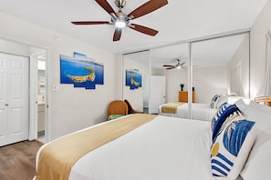 A hotel room with a large bed, a ceiling fan, and artwork on the walls. - Recently updated spacious 1bd in Maui (Kihei)