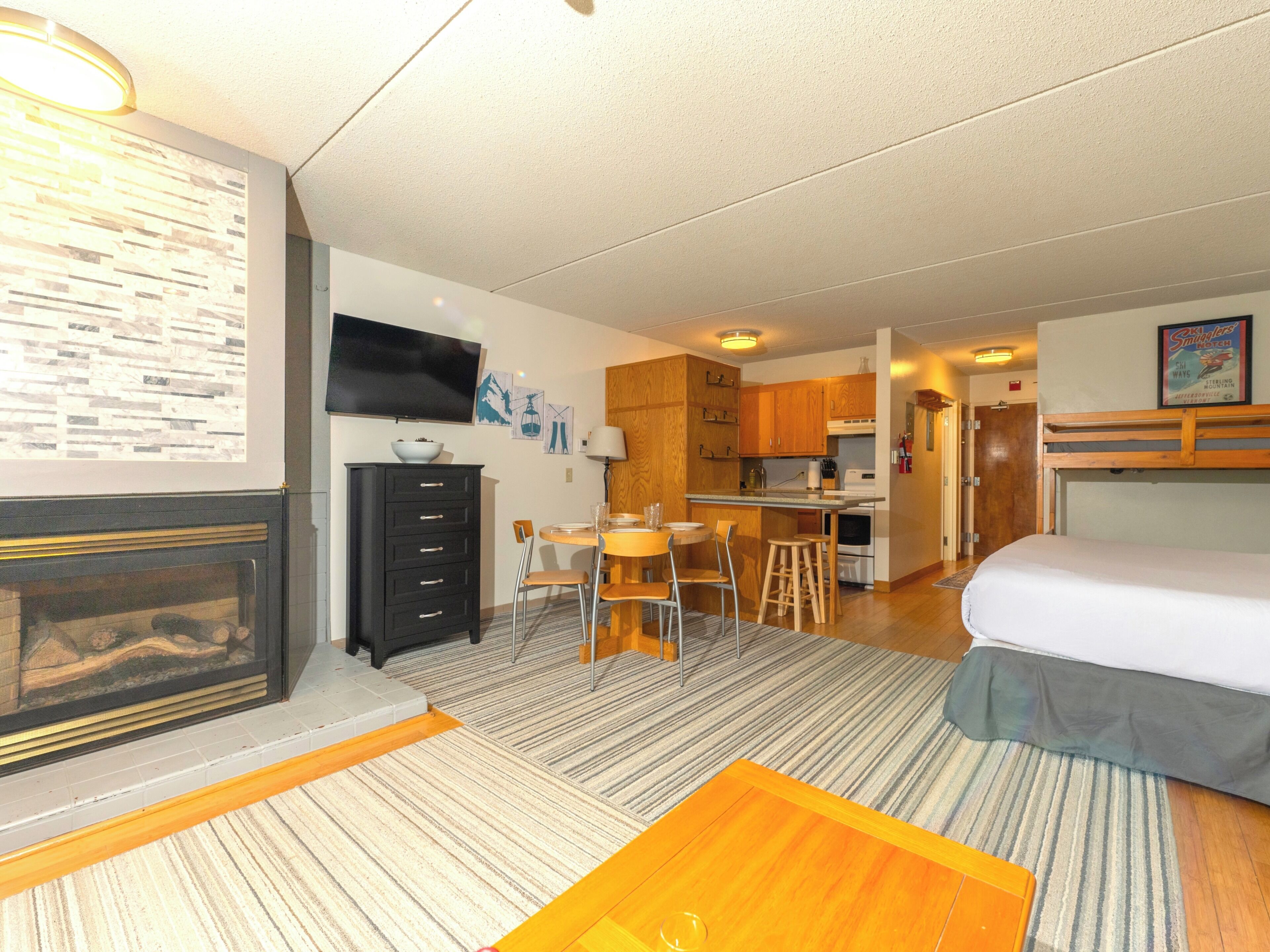 Une chambre d’hôtel compacte comprenant un coin cuisine, un espace repas et un lit.