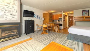 A compact hotel room with a kitchenette, a dining area, and a bed. - Ski-in, Ski-out Studio Condo at Smugglers' Notch Resort (Cambridge)