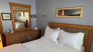 A neatly made bed with white linens, a wooden headboard, and a large mirror above it. - Cozy 3-bedroom home Brownington, VT-On VASA Trails - Near Lake Willoughby (Brownington)