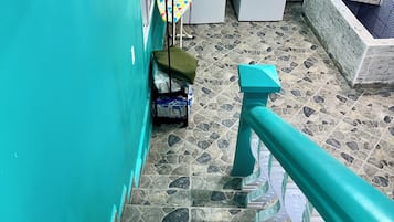 Zona de lavandería con dos lavadoras, un tendedero y piso de baldosas.