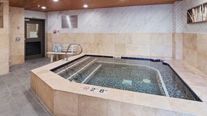 A hot tub with a tiled floor and a wooden ceiling. - Carriage House 101 | Kitchenette | Near Dining & Shopping | Hot Tub | Pool (Park City)