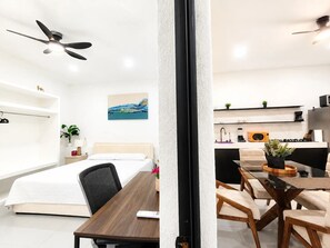 Ein modernes Hotelzimmer mit Bett, Nachttisch und Deckenventilator.
