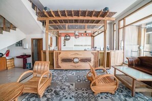 A modern kitchen with a central island, wooden chairs, and a dining table. - Blok O International Guest House by MHM (Banguntapan)