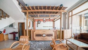 A modern interior with a central wooden structure, patterned floor, and wooden furniture. - Blok O International Guest House by MHM (Banguntapan)