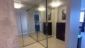 Un interno moderno con una parete divisoria in vetro, faretti a soffitto e un camino in pietra.