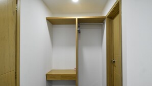 Una habitació petita i tancada amb una porta de fusta, una petita estant i un escuriadents.