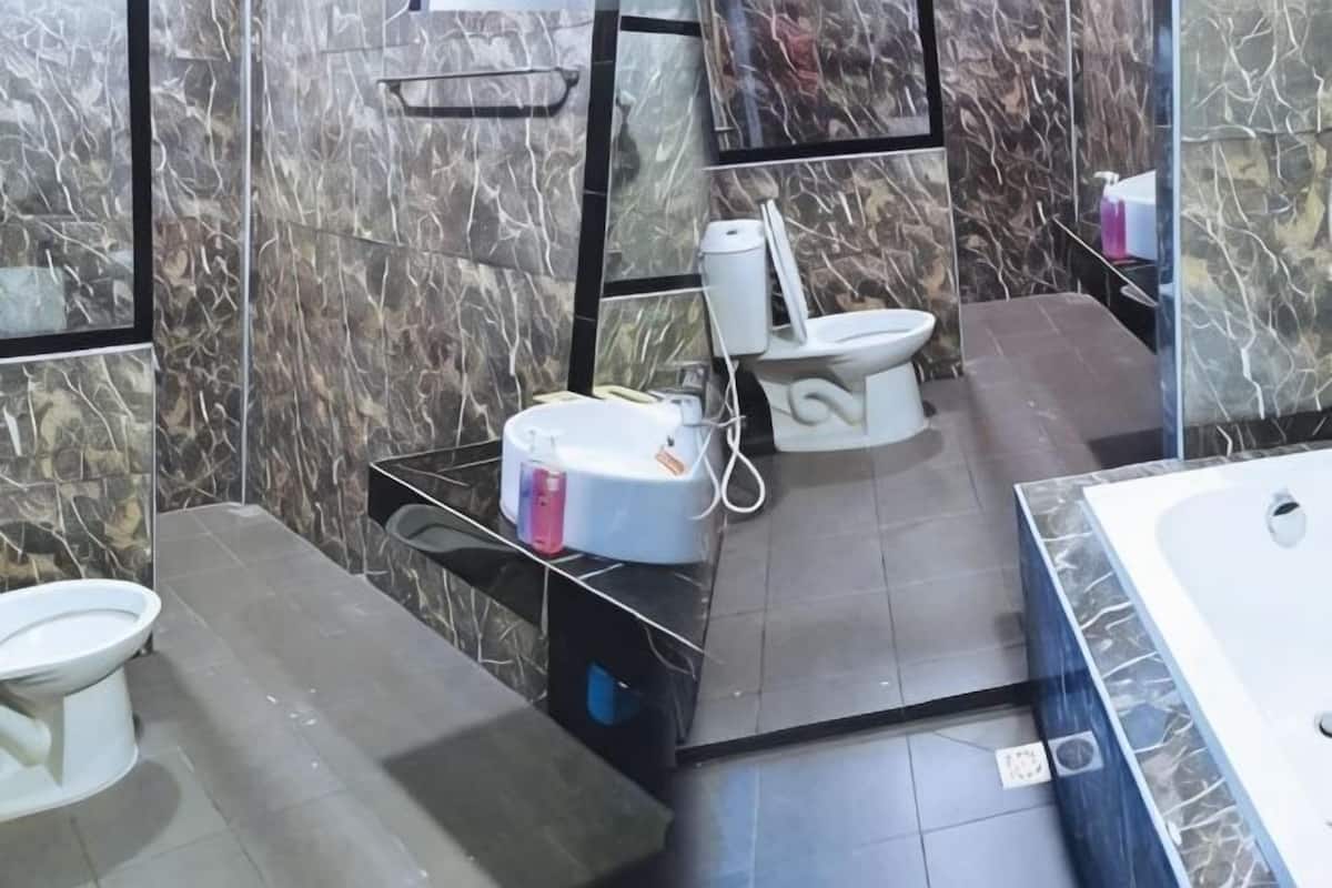 A bathroom with a toilet, bidet, and bathtub.