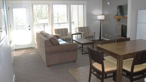 Una sala de estar con sofá, sillas, una mesa de comedor y una chimenea.