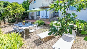 A patio with outdoor furniture, a table, and a chair.
