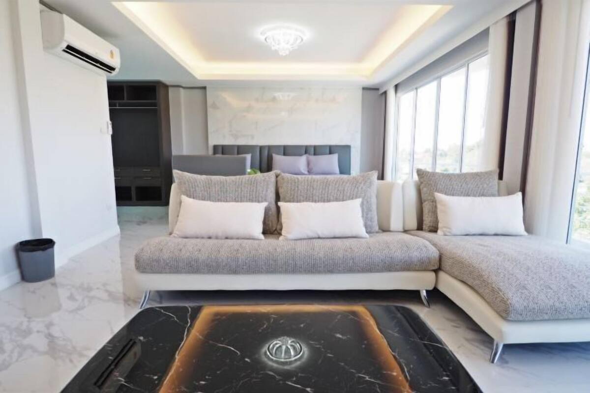 A modern living room with a sofa, a coffee table, and a TV.