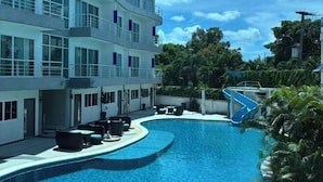 Een modern hotel met een zwembad, terras en een glijbaan.