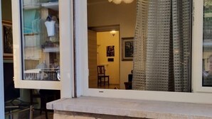 A room with a view through a window, a brick ledge, and a chair inside. - Happy Home Piramide Cestia Lussuoso Unico Esclusivo a Roma (Rome)