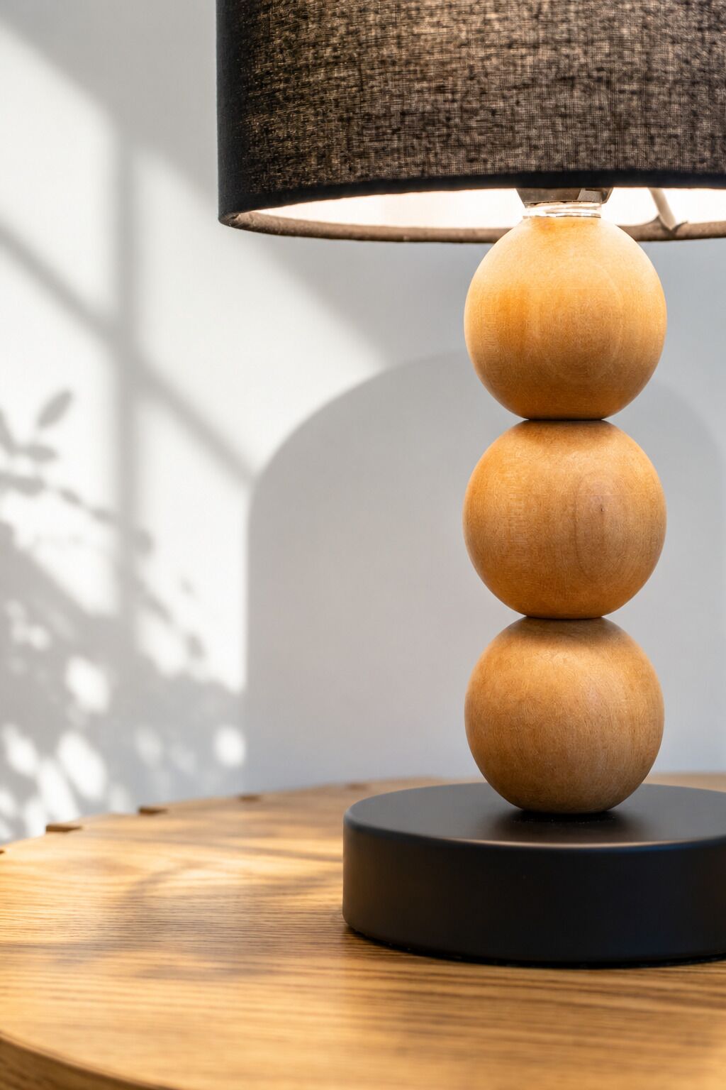 Une lampe avec un abat-jour texturé et un pied en bois, posée sur une table ronde.