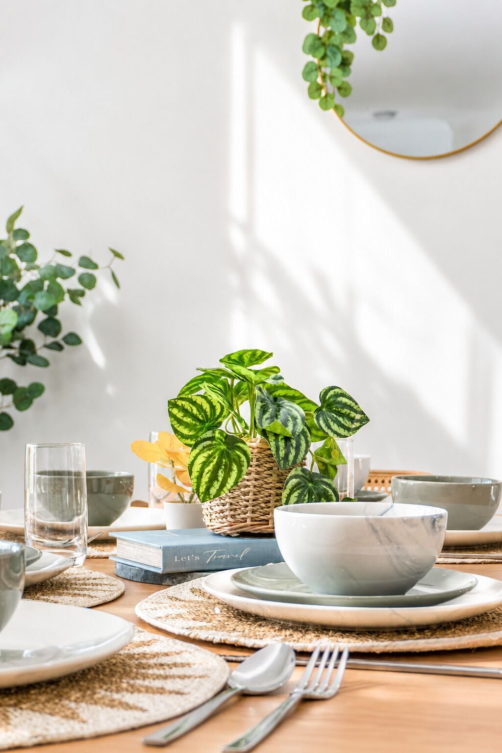A dining table set with plates, bowls, and a book titled 'Let's Travel'.