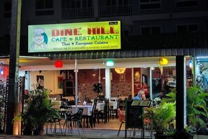 A cafe with outdoor seating and a neon sign advertising Thai and European cuisine. - New Nordic Trend 4 by Apartwell (Pattaya)