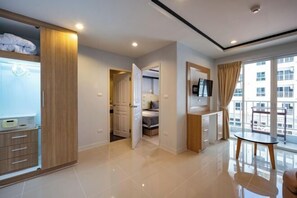 Una habitación de hotel moderna con cama, escritorio, televisor y balcón con vistas.