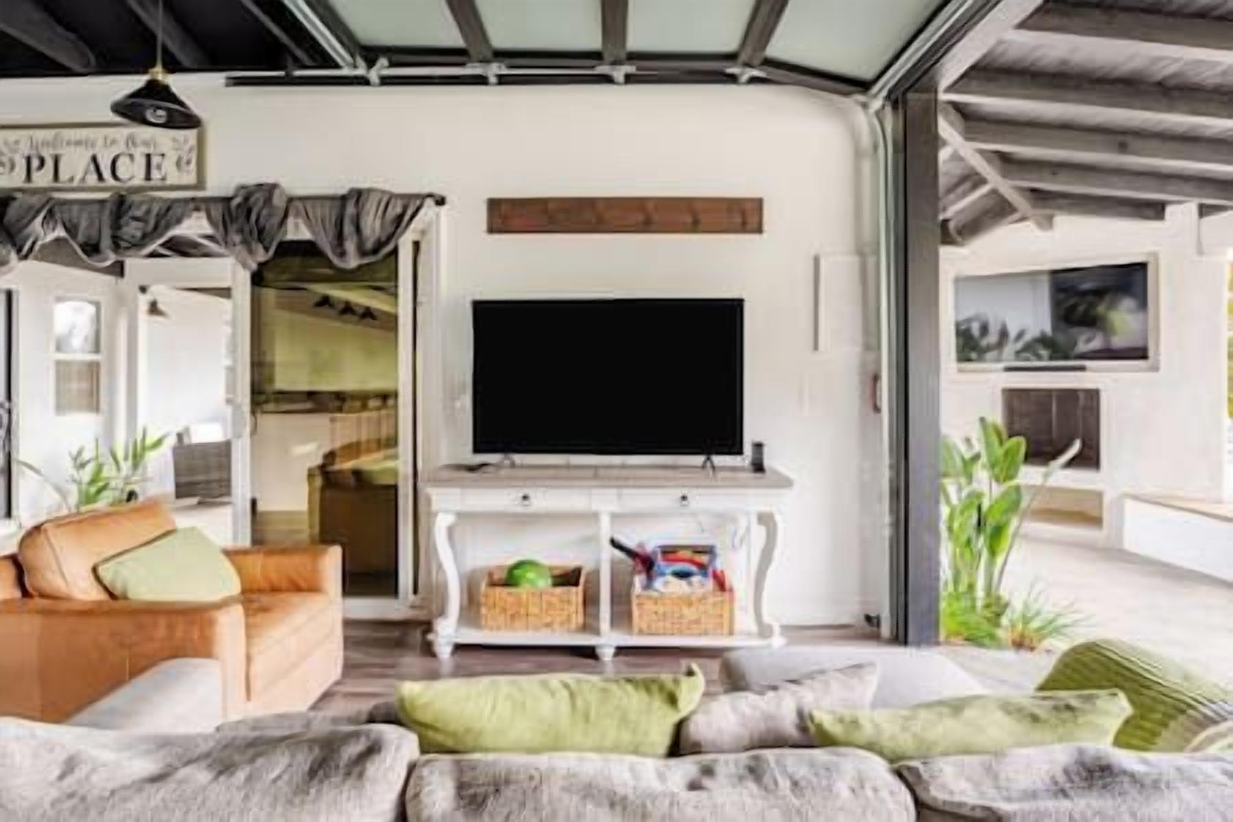 A living room with a flat-screen TV, a sofa, and a coffee table.