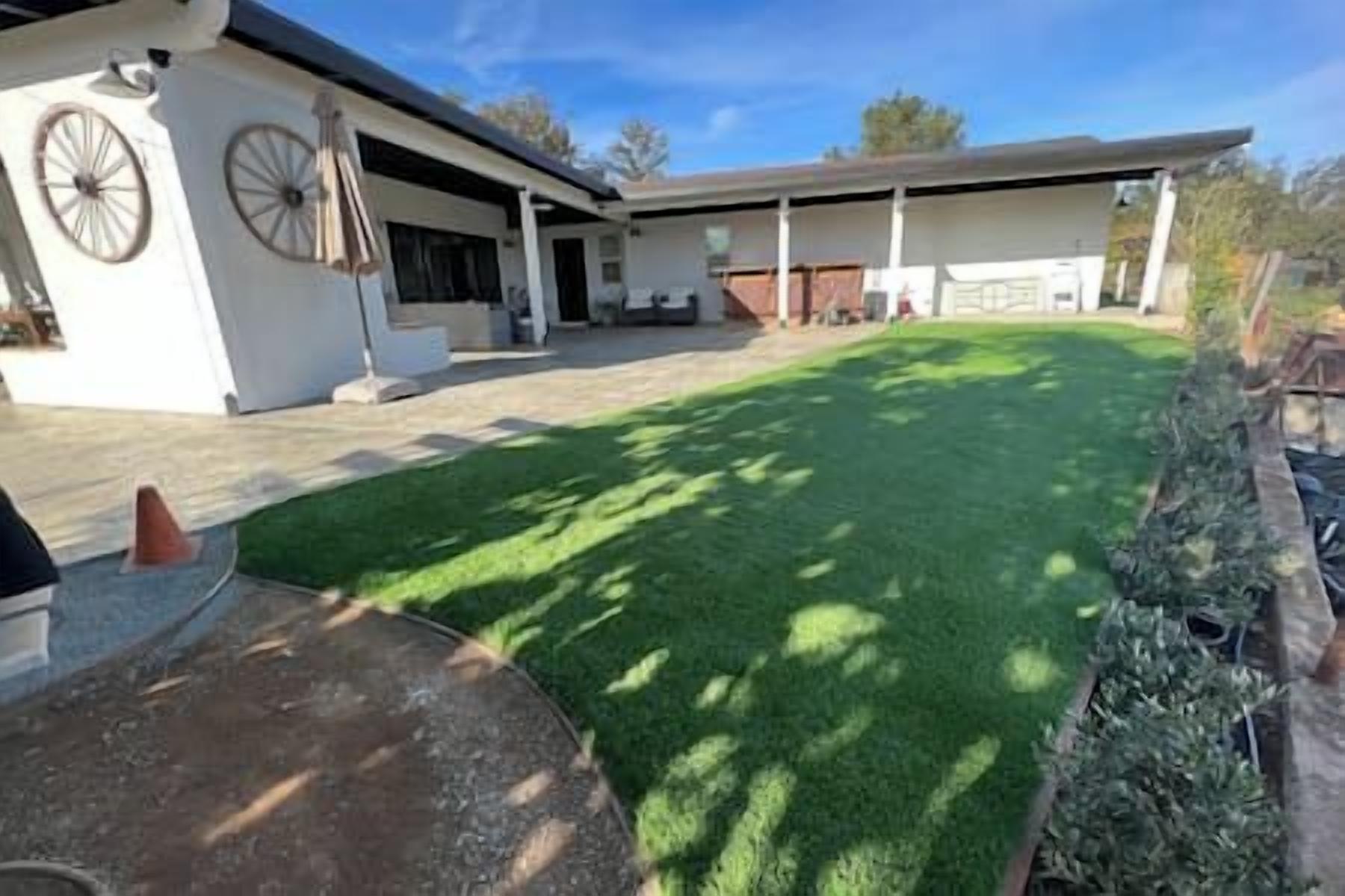 A residential property with a well-maintained lawn, a patio area, and a garage.