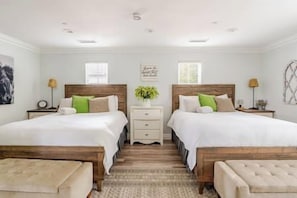A double room with two beds, a nightstand, a bedside table, and a window.