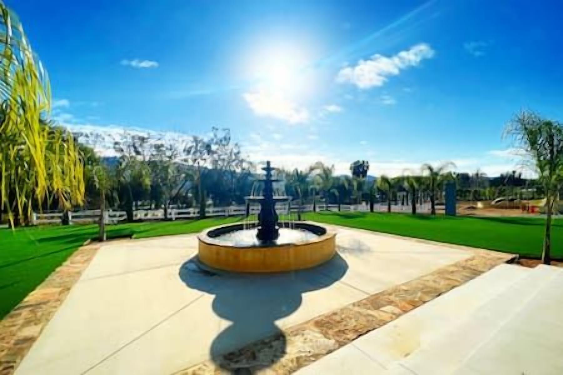 A fountain in a park with a clear sky.
