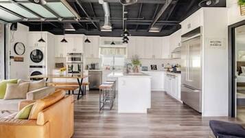 A modern kitchen with white cabinets, a central island, and stainless steel appliances.