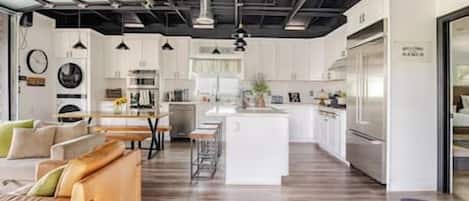 A modern kitchen with white cabinets, a central island, and stainless steel appliances.