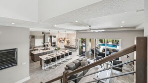 Ein geräumiger, offener Wohnbereich mit Küche, Essbereich und Blick auf einen Swimmingpool.