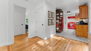 A kitchen with white walls, wooden cabinets, and a red stove. - Dahlia House: 3 BDRM home in Highlands, NC, just a short walk to town. (Highlands)