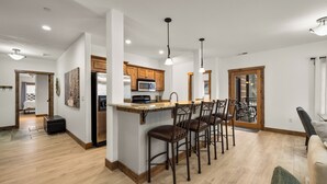 Una cocina amplia con una isla central, armarios de madera e iluminación colgante.