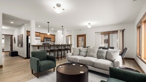 Una sala de estar moderna con un sofá, sillones y una mesa de centro.