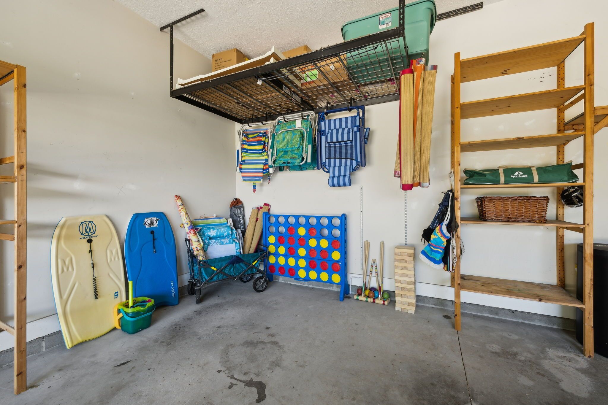 A storage room with surfboards, a wall-mounted pegboard, and shelves.