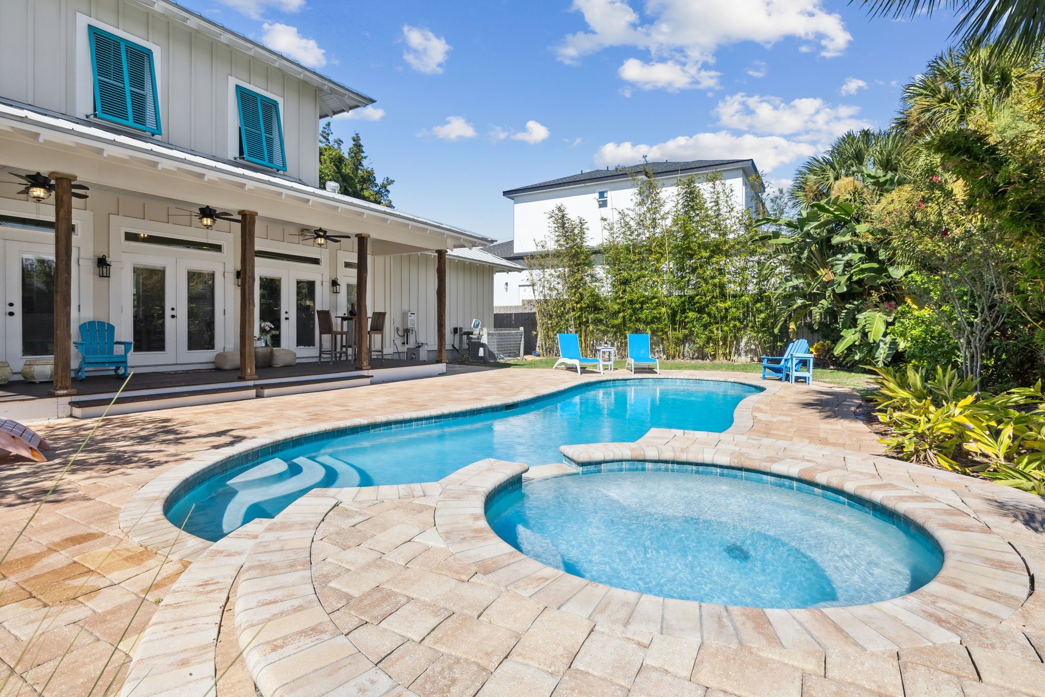 A swimming pool with a curved design, surrounded by a stone patio.