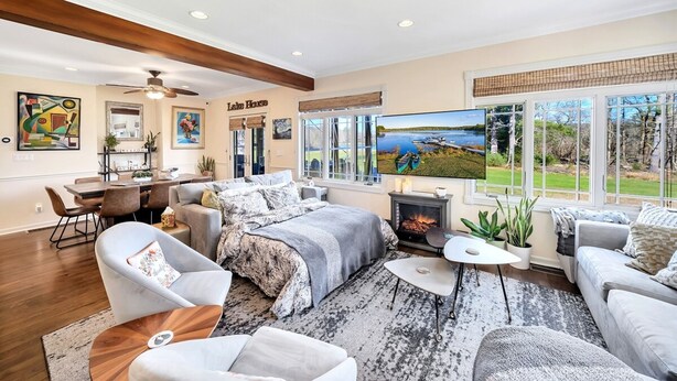 A spacious living room with a fireplace, comfortable seating, a dining area, and large windows with a lake view. - 2 Lake Cabins Pool Hottub Game Room 23acs (Highland Lake)