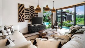 Una sala de estar moderna con un sofá, televisión y obras de arte en la pared.