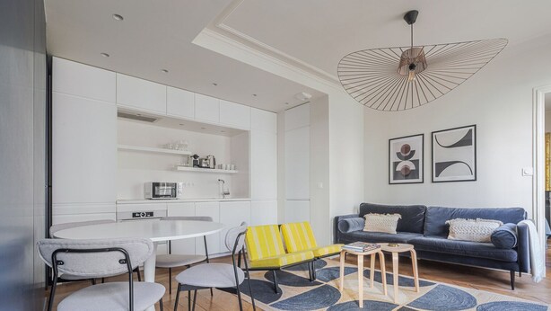 A modern living room with a blue sofa, a yellow armchair, and a white dining table. - Blueground | Saint Vincent de Paul, view, nr Canal (Paris)