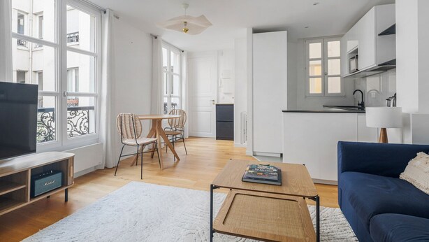 A modern apartment with a living room, dining area, and kitchen.