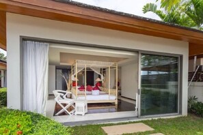 A room with a canopy bed, a sliding glass door, and a small outdoor seating area. - Baan Ban Buri (Koh Samui)