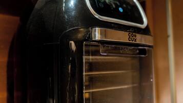A black coffee maker with a digital display and a brand name on a wooden countertop.