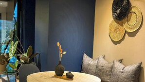 A modern dining area with a round table, chairs, a vase with dried flowers, and decorative wall art. - Terrario las acacias  (Armenia)