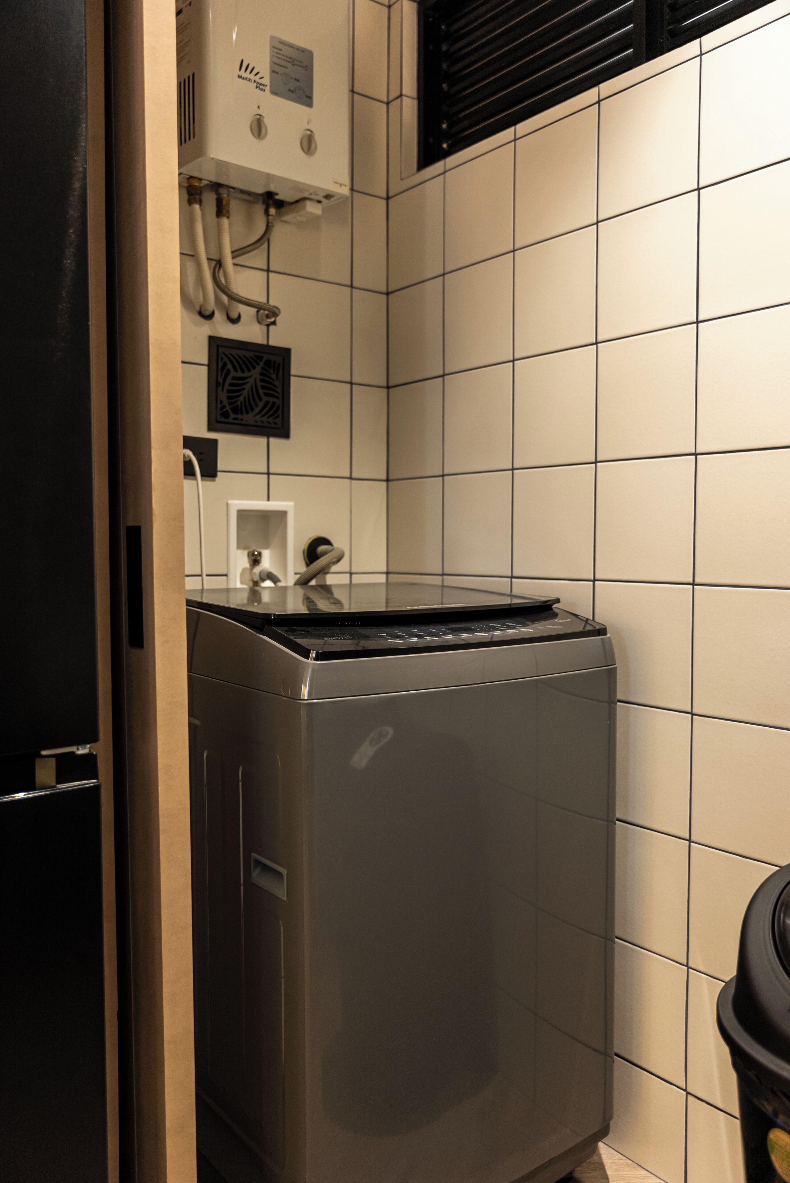 Una cocina compacta y moderna, con lavavajillas integrado, una pequeña encimera y una campana extractora de pared.
