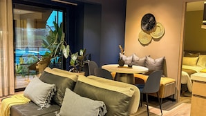 A modern living room with a sofa, chairs, a small round table, and a view of the outdoors. - Terrario las acacias  (Armenia)