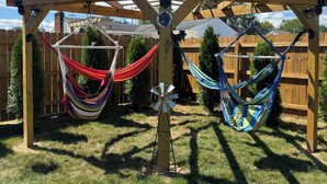 Una pérgola de madera con dos hamacas colgadas.