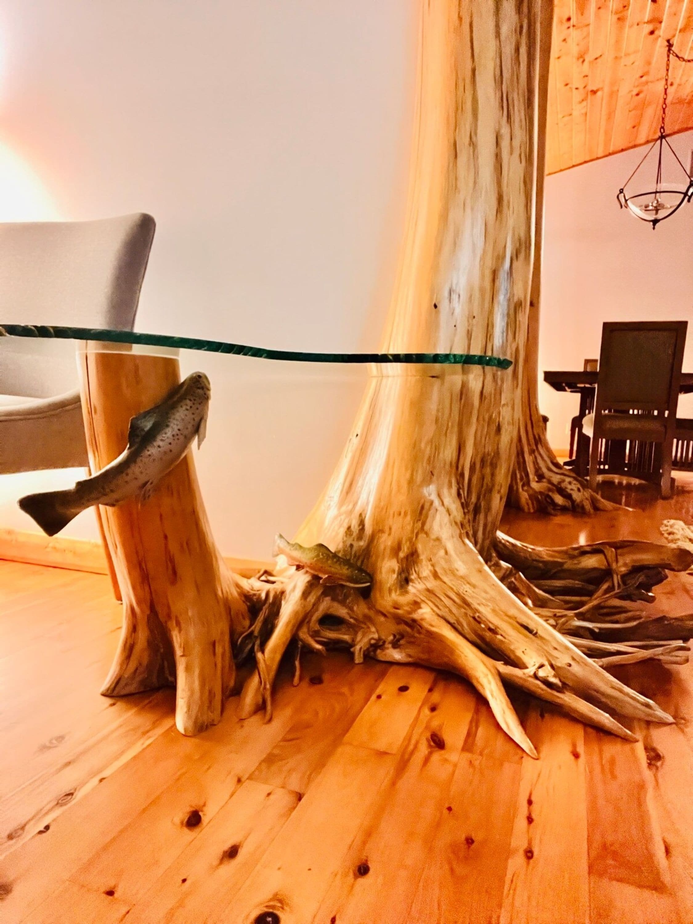 A wooden floor with a glass table and chairs.