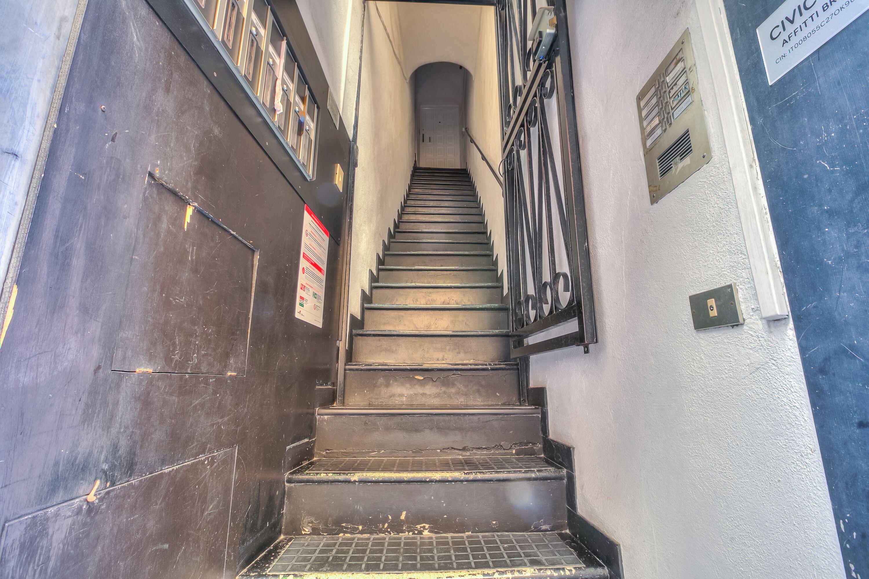 A staircase leading to a door with a sign above it.