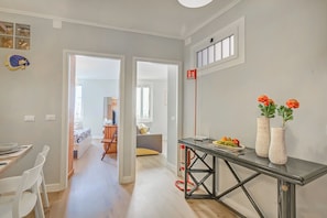 A modern kitchen with a dining area, a hallway leading to another room, and a fire extinguisher mounted on the wall. - Armonia Centrale - Sanremo Apt for 4 with A/C, Sanremo, Italy (Sanremo)