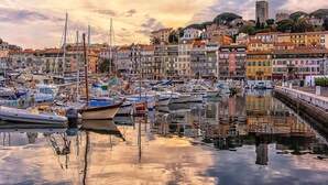A marina with boats docked, a waterfront promenade, and colorful buildings in the background. - Cannes Center - 5min from Croisette & Pal, Cannes, France (Cannes)
