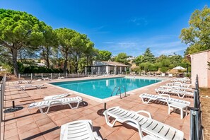 A swimming pool with lounge chairs and a building in the background. - Cosy Apartement Gaia Villeneuve-Loubet, Villeneuve-Loubet, France (Villeneuve-Loubet)