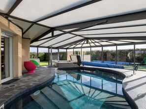 A covered outdoor swimming pool with a hot tub, seating area, and a view of the surrounding garden. - Chez David by Interhome (Kersaint-Plabennec)